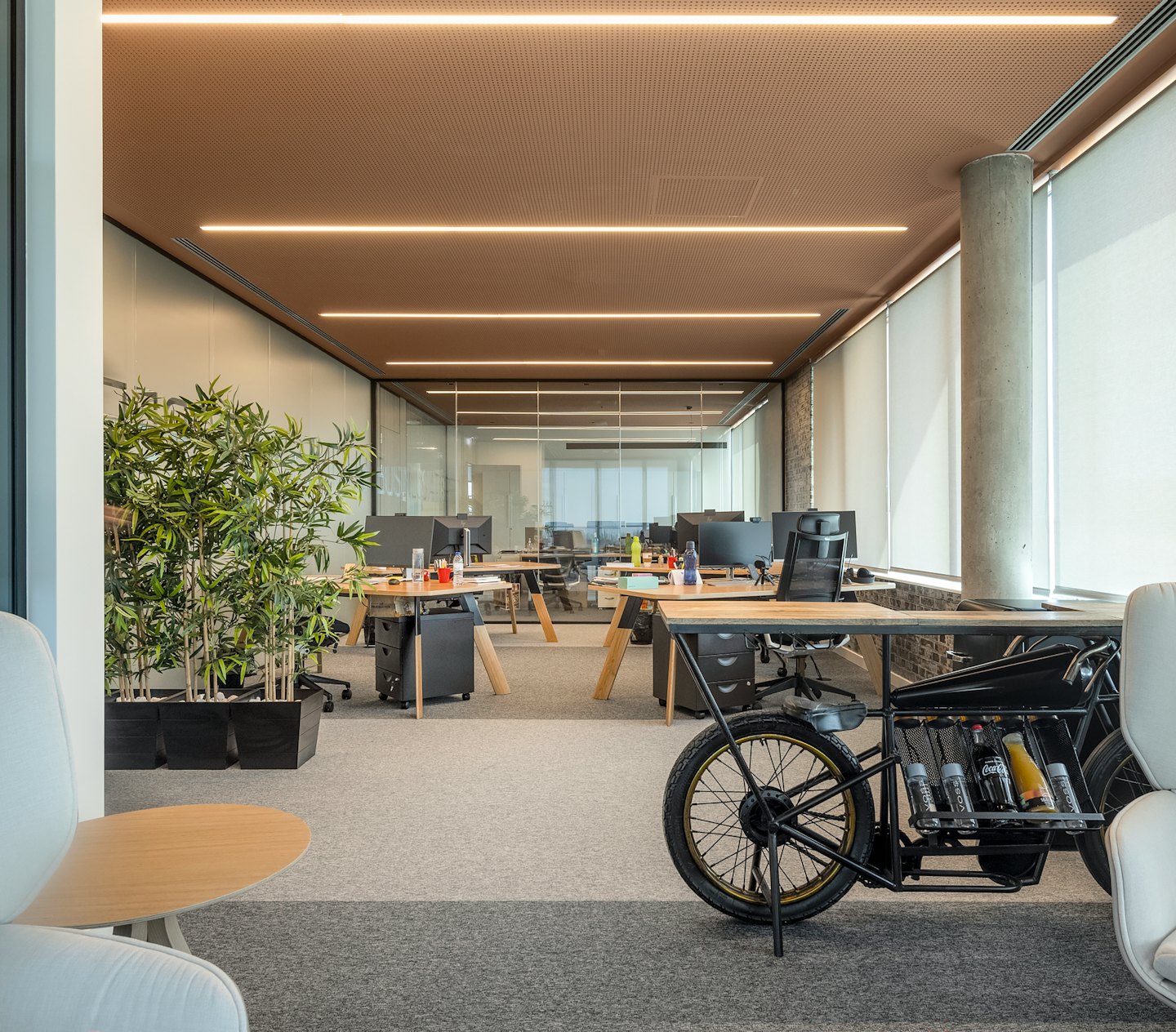 ユニークなバイクのデスクと観葉植物があるモダンなオフィス。